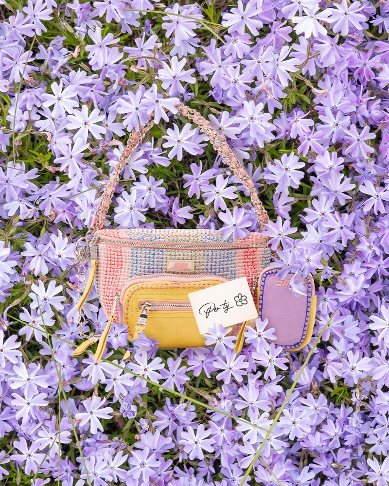 Colorful handbag among purple flowers